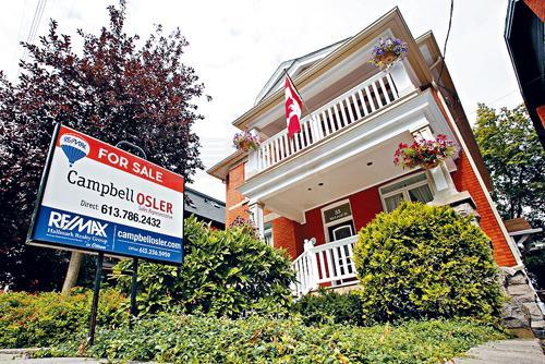 FILE PHOTO: A real estate sign is seen in front of a house for sale in Ottawa, Ontario, Canada, August 15, 2017. REUTERS/Chris Wattie/File Photo