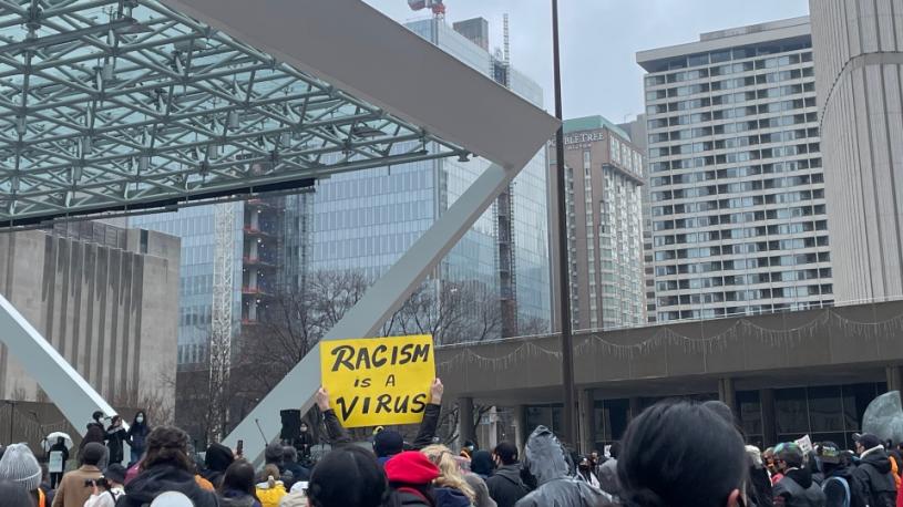 在集會上，有人高舉「種族主義是一種病毒」的標語牌。CTV