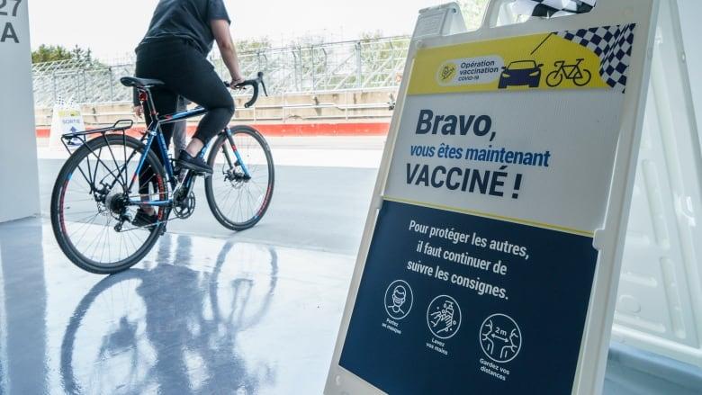 ■ 一個滿地可市民接種疫苗後騎單車離開。加通社
