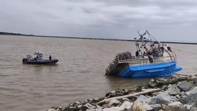 渔船在岸边岩石上搁浅。推特视频截图
