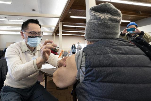 一名医生在卑诗省列治文一所疫苗诊所为市民接种新冠疫苗。加通社