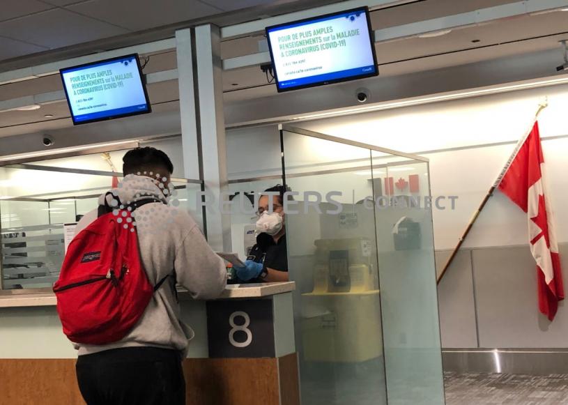多倫多皮爾遜國際機場的邊境人員於去年3月檢查入境人士的旅遊證件。路透社
