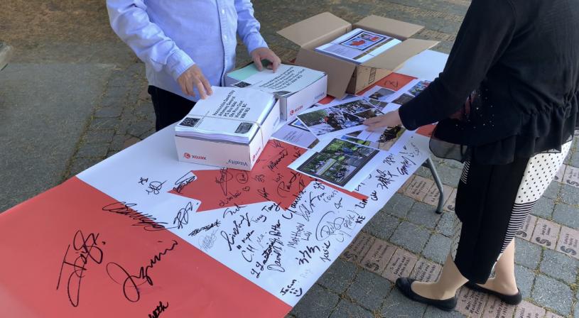 “反对仇恨亚裔犯罪关注组”展示收集的签名。  张誉摄