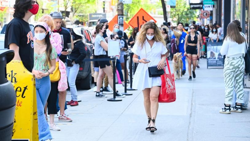 上月多伦多市中心皇后西街上长长的人龙，顾客排队等候进入商店购物。加通社