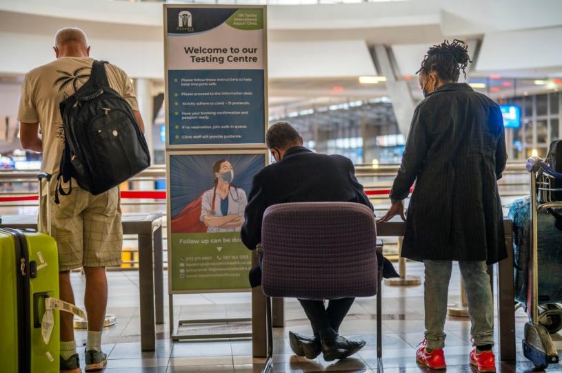 旅客周五在南非奥利弗坦博国际机场，排队轮候接受病毒检测。 美联社