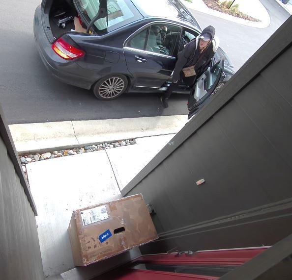 闭路电视拍得一名女子下车，擅自搬走放置于门前的包裹，然后放入车尾箱。 本拿比皇家骑警