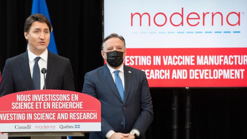 杜鲁多宣布在满地可建立一个新的疫苗生产设施，他身后为魁省省长勒格。加通社