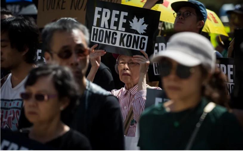 2019年8月3日檔案圖片，一名婦人手持標語牌，在溫哥華遊行，支持香港反修例運動。 (加通社)