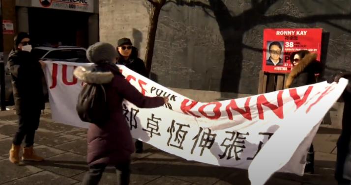 集會人士拉起用中文寫有「為祁卓恆伸張爭議」的橫額。Global News視頻截圖