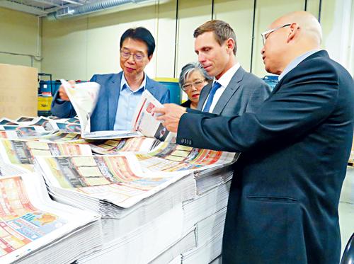 彭建邦与2名华裔候选人韦邱佩芳（左2）及柯文彬（右1）翻阅本报报纸。本报记者摄