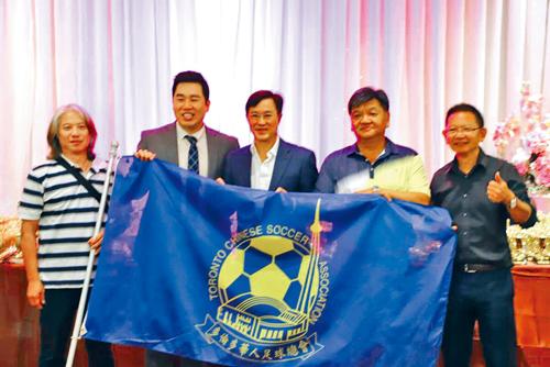 將帶領多倫多華人足球隊赴香港參加比賽的謝振漢，接受陳聖源授旗。