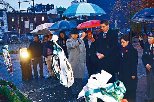 谢尔（右2）、黄陈小萍（右1）联同华裔老兵冒雨向先侨纪念碑献花及鞠躬。冯瑞熊摄