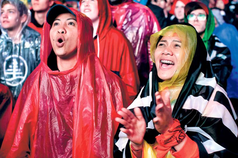 ■猛龍球迷在侏羅紀公園冒雨觀看比賽，七情上面。 加通社