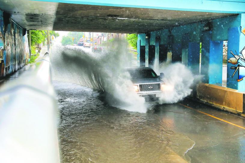■多伦多一条高架桥下通路水浸，汽车要涉水而行。　星报