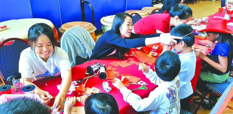在國慶日活動上，教小朋友手工製作。    文化中心提供
