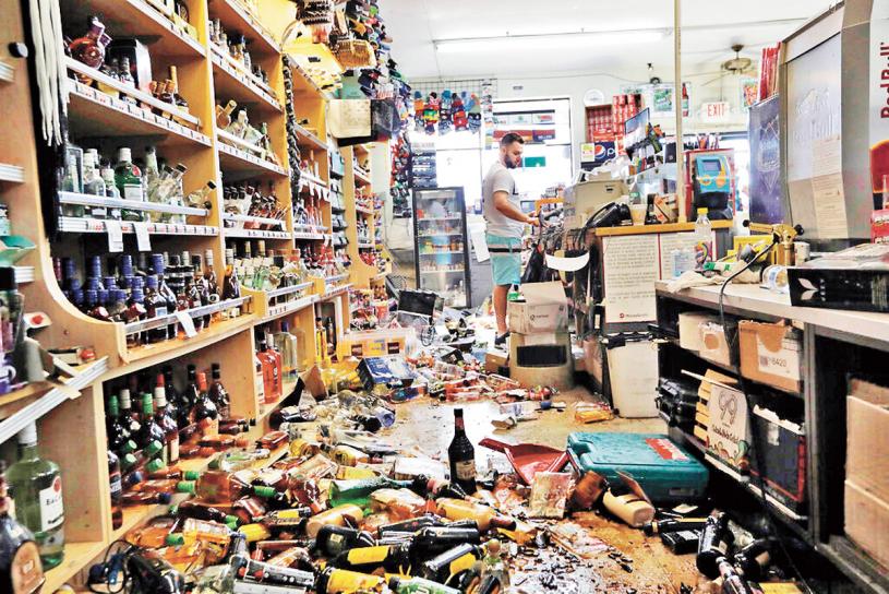 震央附近一间杂货店，柜上酒类饮料被震落一地。美联社