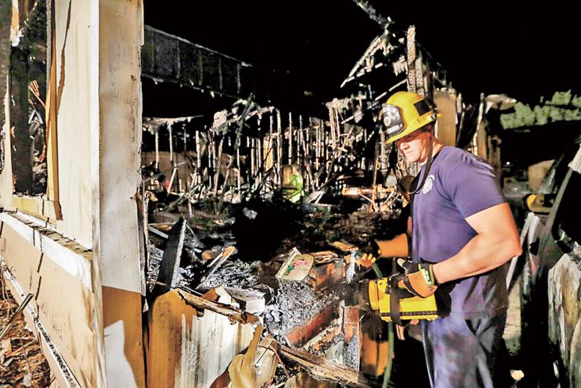 消防队员查看因地震引发大火的民宅。
美联社