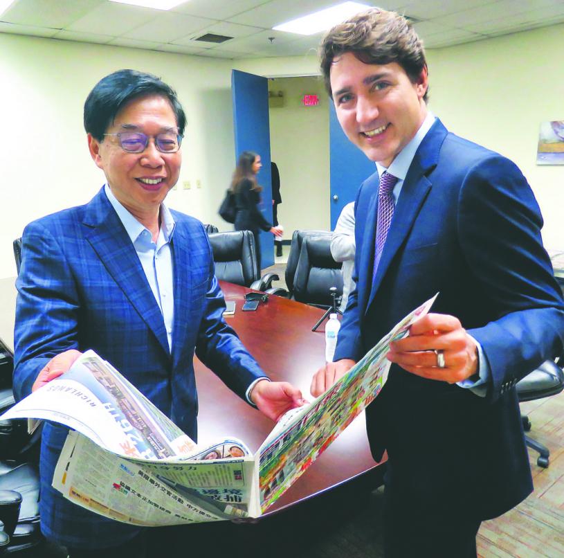 杜鲁多在加拿大星岛传媒集团行政总裁黄敬强陪同下，参观报馆运作并阅览昨日出版的报纸。