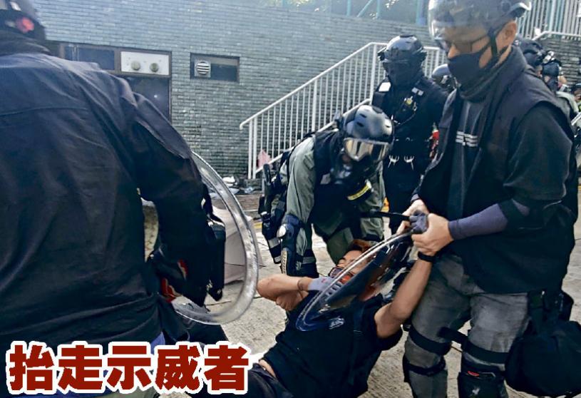 ■防暴警将一名被捕示威者抬走。林思明摄