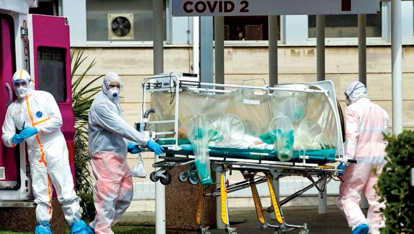 ■在意大利新冠病例激增，衛生系統不堪重負，圖中羅馬一名病人正被從救護車上抬出。美聯社
