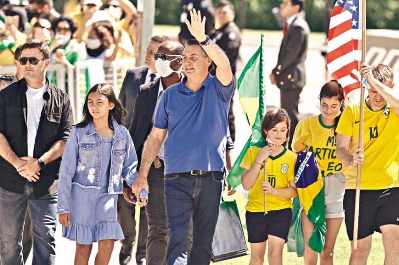 巴西總統博索納羅（中）日前仍參加集會，且不戴口罩。 美聯社