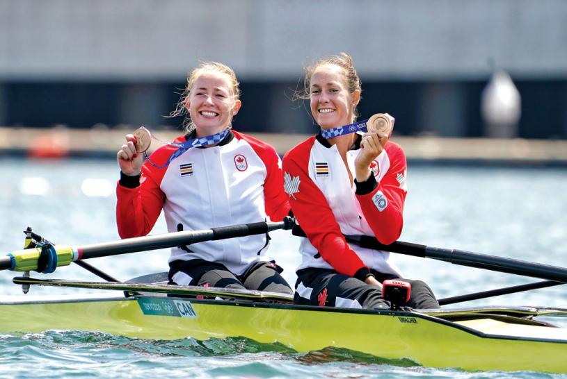 加拿大女子双人划艇选手在领奖后，向大家展示这面铜牌。加通社