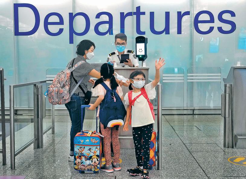 ■隨著加英等國放寬對香港人申請的移民要求，香港機場近日每天均有很多人乘機離開。圖中的小女孩正向朋友揮手告別。美聯社