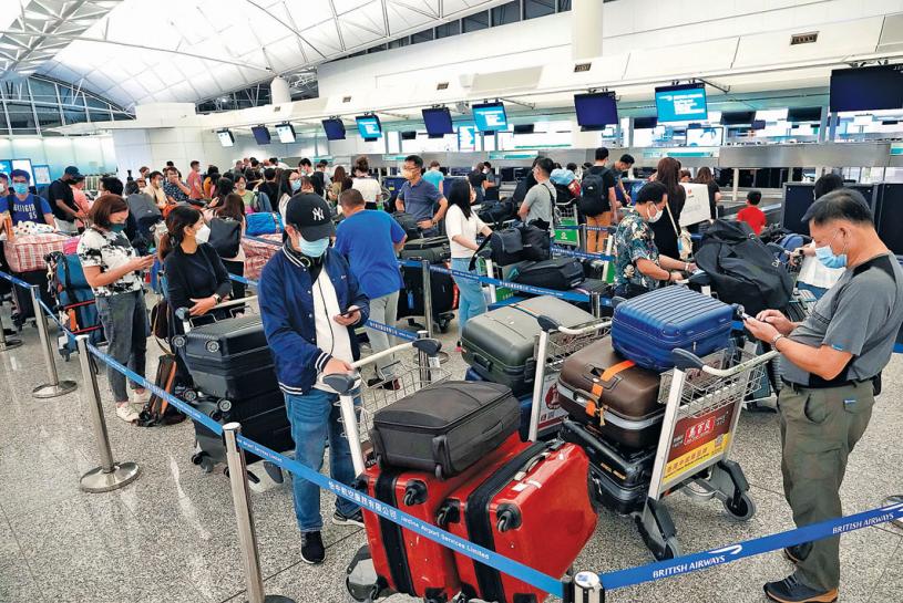 ■在香港機場排隊等候辦理登機手續的人群中，不乏持BNO移居英國的港人。美聯社