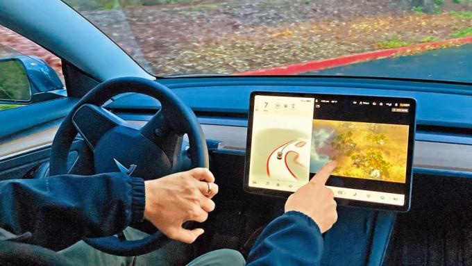 波特蘭特斯拉新車主巴頓示範一a邊開車，一邊玩遊戲。