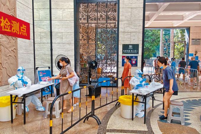 深圳南山区居民在屋苑内排队，接受核酸检测。