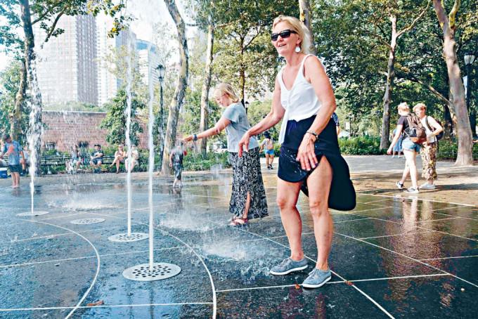 美国多地酷热，人们在纽约曼哈顿一个公园里喷水消暑。　
