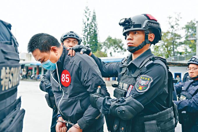 特警押送缅北电讯嫌犯返华。