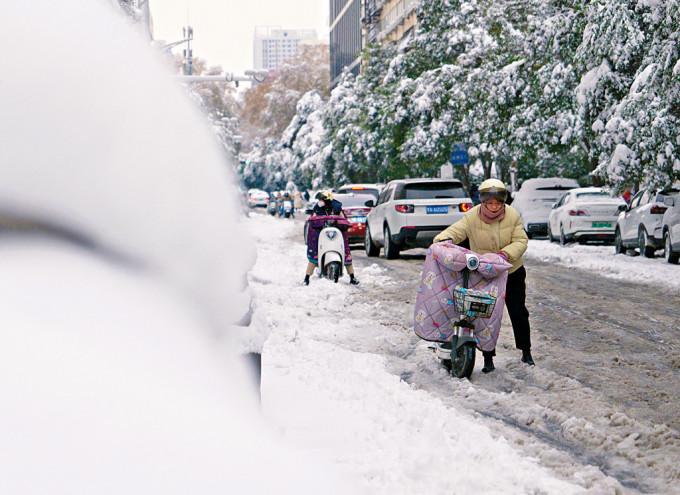 郑州市民在雪地里推车前行。

