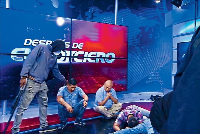 厄瓜多尔TC电视台直播画面可见蒙面枪手挟持电视台员工。
