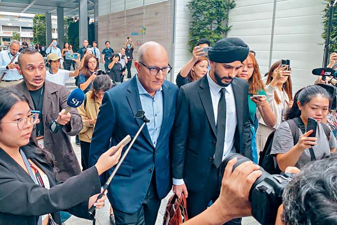 新加坡交通部部長易華仁（中左）周四出庭後離開國家法院。
