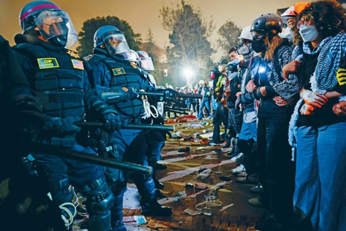 防暴警察周四摧毁UCLA校园内部分营地路障后，与亲巴勒斯坦学生对峙。
