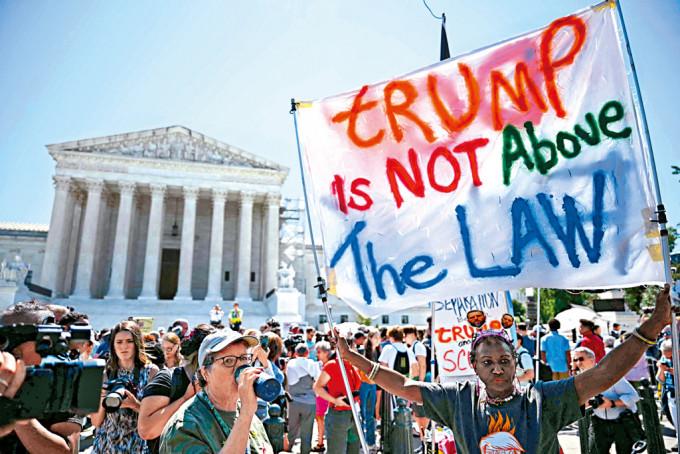 示威者周一在华府展示“特朗普不能凌驾法律”标语，抗议最高法院有关总统豁免权的裁决。
