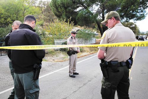 Law enforcement officers stand near one of many crime scenes after a shooting on November 14, 2017, in Rancho Tehama, California
Four people were killed and nearly a dozen were wounded, including several children, when a gunman went on a rampage at multiple locations, including a school in rural northern California. / AFP PHOTO / Elijah Nouvelage