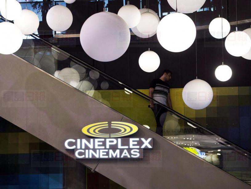 A man makes his way down an escalator during the Cineplex Entertainment company's annual general meeting in Toronto on Wednesday, May 17, 2017. Cineplex Inc. is laying off 