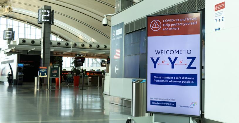 TORONTO, CANADA - April 18, 2020: Social distancing warning sign posted inside a vacant Terminal 1 at Toronto Pearson Intl. Airport during the peak of the COVID-19 pandemic.