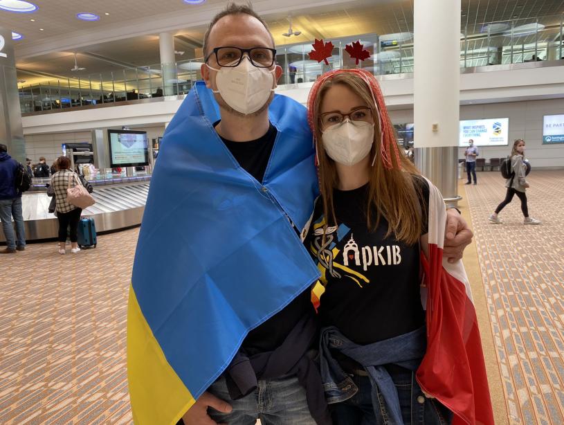 帕夫洛夫婦披著烏克蘭國旗在機場等候。Twitter
