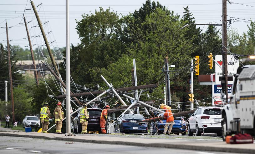 消防員及技術人員於渥京Merivale路成堆倒塌的電線、電線桿和交通信號燈中工作。加通社
