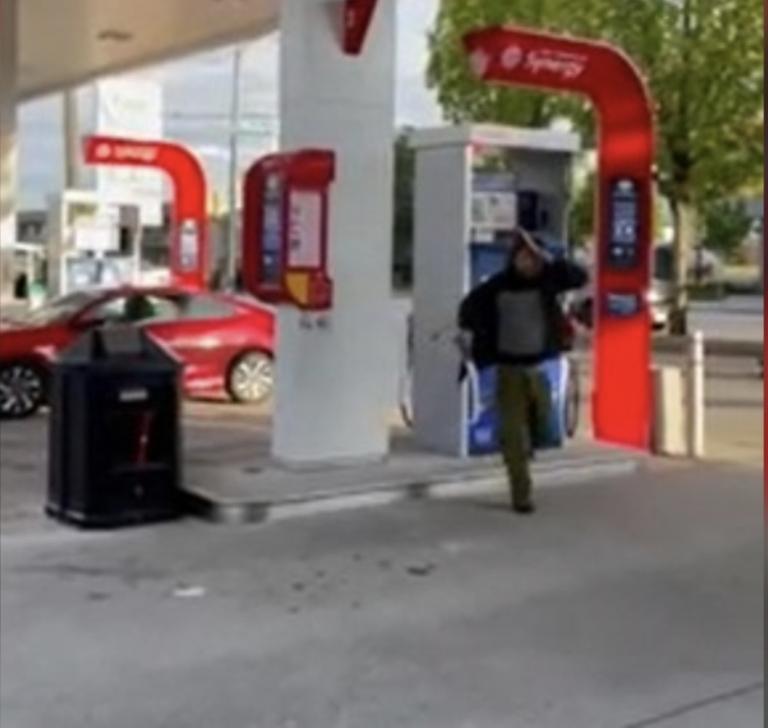 视频显示一男子手持砍刀在油站横冲直撞。   视频截图