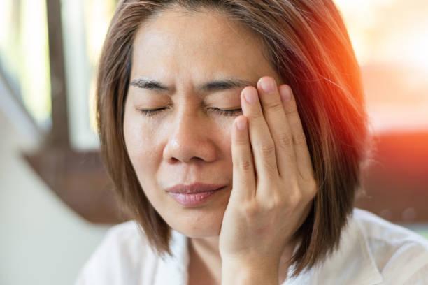 TMD and TMJ healthcare concept: Temporomandibular Joint and Muscle Disorder. Asia man hand on cheek face as suffering from facial pain, mumps or toothache