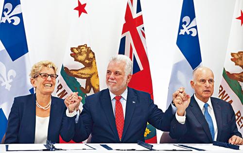 安省省長韋恩（左）、魁省省長高拿達（中）和加州州長布朗（右）在周五簽署協定。
美聯社