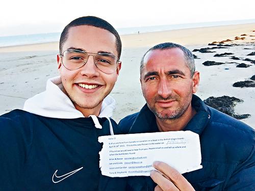 撒德旦（左）與父親在鄧寇克沙灘上發現玻璃瓶中的字條。 受訪者提供

