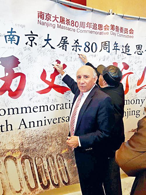 白必勤在纪念南京大层杀80周年活动签名悼念死难者。