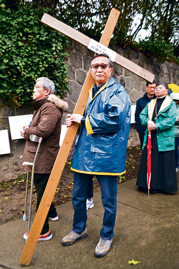 ■朱伟光携大型十字架参加抗议活动。