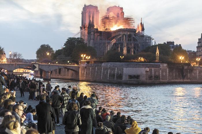 ■民眾眼睜睜看著巴黎聖母院陷入火海，神情肅穆，默默禱告。法新社