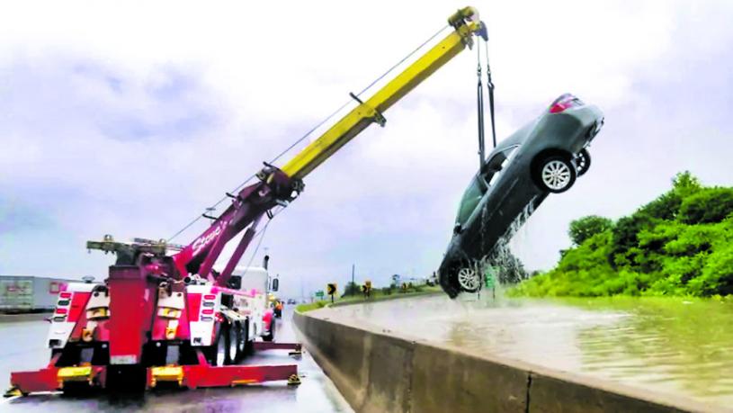 ■一架起重機將一輛汽車從水中吊起。 CBC